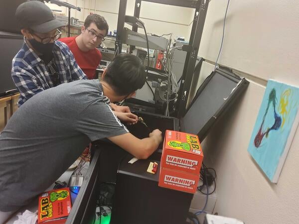 Sean Preins, Miguel Rodriguez and JiaJun Huang discussing about a setup