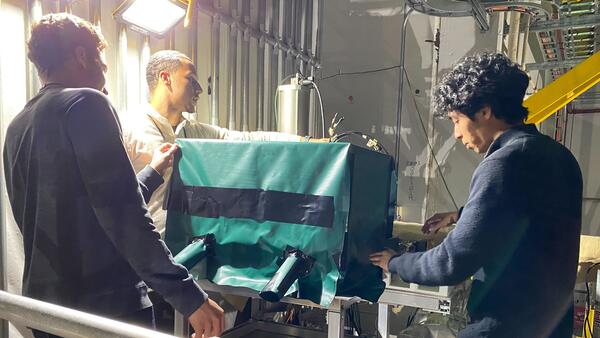 Yousef Abdelkadous, Peter Carney and Ryan Tsaio working installing a dark enclosure for Calorimeter Insert Prototype